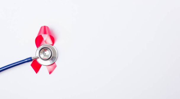 Breast cancer month concept, flat lay top view, pink ribbon and stethoscope on white background with copy space for your text - 写真・画像