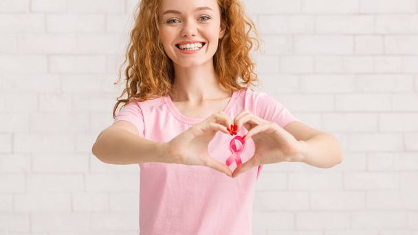Girl Framing Pink Ribbon Forming Heart Shape From Hands, Panorama - Zdjęcie, obraz