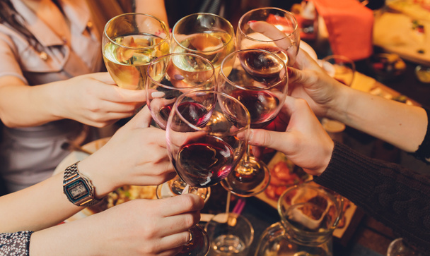 Zbliżenie ujęcia grupy ludzi brzęczących kieliszkami z winem lub szampanem przed bokeh tle. osoby starsze ręce. - Zdjęcie, obraz