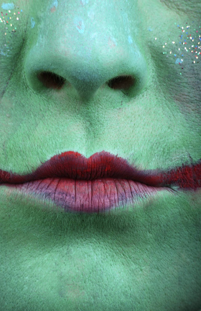 close up of a woman's face with a green lips - Фото, изображение
