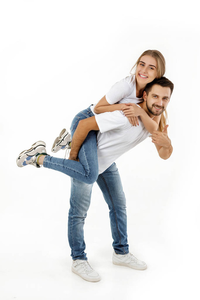 boyfriend giving piggyback to girlfriend on white background - Φωτογραφία, εικόνα