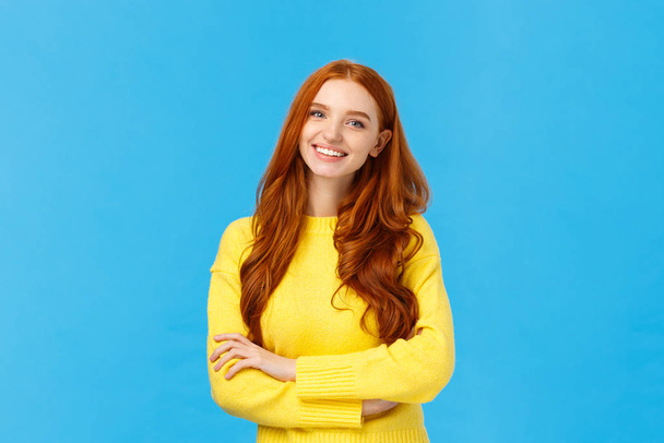 People, communication and lifestyle concept. Waist-up shot cheerful outgoing redhead pretty woman with curly hair, yellow sweater, cross arms chest relaxed pose, smiling, chatting coworker - Fotografie, Obrázek