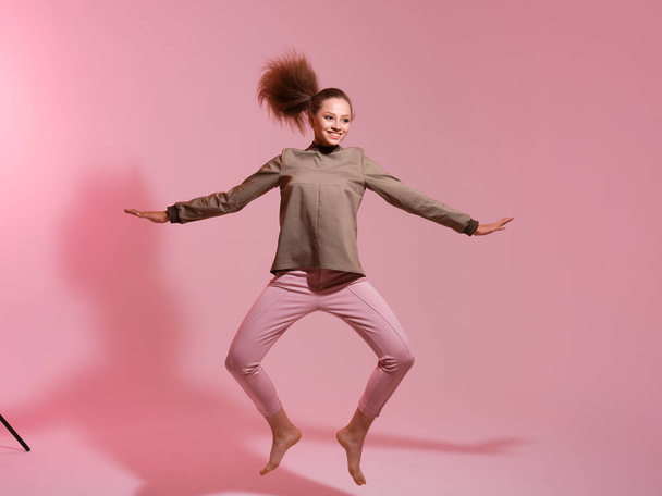 studio shot of young woman jumping  - Foto, afbeelding