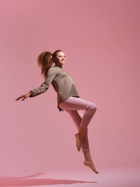 studio shot of young woman jumping  - Фото, зображення