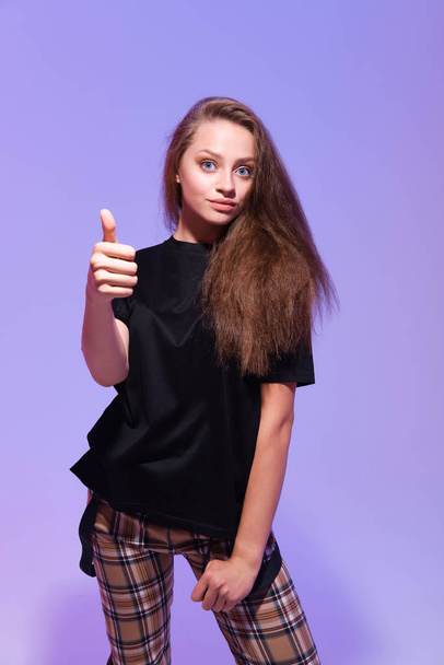 studio shot of young woman showing thumb up - Foto, afbeelding