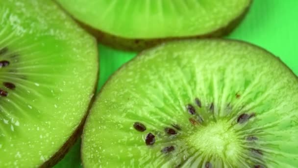 plátek šťavnatého čerstvého kiwi otáčí na stole v detailu - Záběry, video