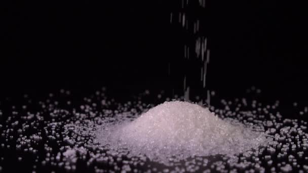 slow-motion sugar drop close-up on a black background - Video