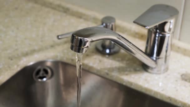 Verser l'eau d'un robinet dans une cuisine. Concept. Gros plan de l'eau qui coule du robinet
 - Séquence, vidéo
