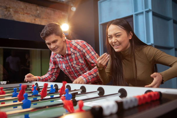 Group of friends playing table soccer at beer pub - Foto, Bild