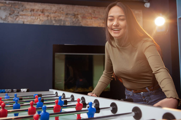 Young Asian woman playing foosball - Foto, afbeelding