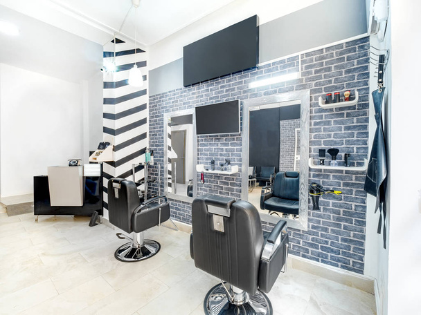 Modern bright beauty salon. Hair salon interior business with industrial minimal look. Black and white decoration with mirrors, chairs,tv screen and mockup banners - Zdjęcie, obraz