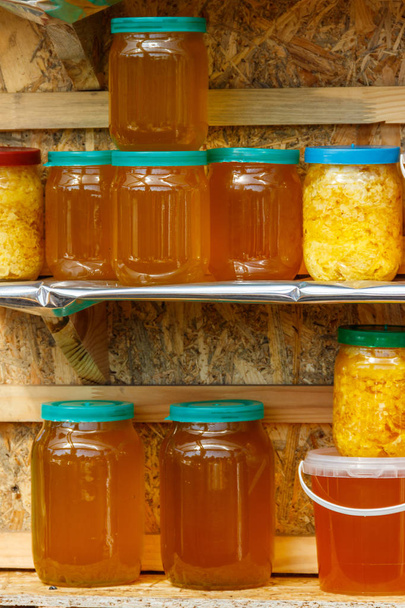 Jars of different honey varieties on a shelf - Photo, Image