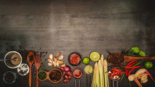 Gewürze zum Kochen von Zutaten auf einem hölzernen Hintergrund mit frischem Gemüse - Foto, Bild