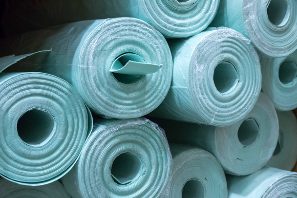 Pile of insulation material rolls. Light green or blue color. Filled frame. - Photo, Image