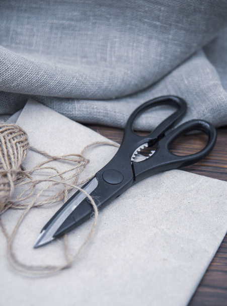 Tools for crafts on a wooden table top. Scissors, thread and paper. - Foto, Imagem