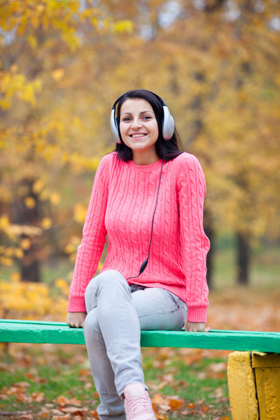 Retrato de una mujer al aire libre con auriculares
. - Foto, Imagen
