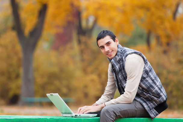 programátor s notebookem sedět v podzimním parku - Fotografie, Obrázek