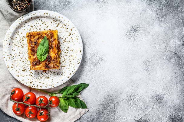 Kotitekoinen italialainen lasagne tomaattikastikkeella ja naudanlihalla. Harmaa tausta. Huippunäkymä. Tekstitila
 - Valokuva, kuva