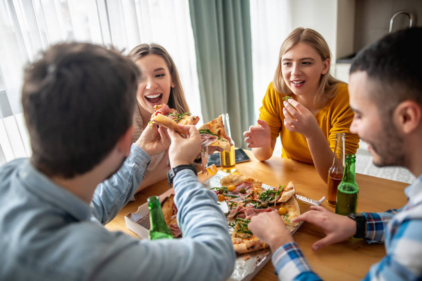 groep vrienden eten pizza thuis - Foto, afbeelding