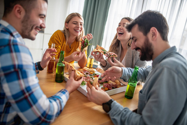 skupina přátel jíst pizzu doma - Fotografie, Obrázek