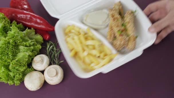 Afhaalmaaltijden verpakken in een piepschuimdoos. Verse pakketmaaltijd met kipnuggets en frietjes  - Video