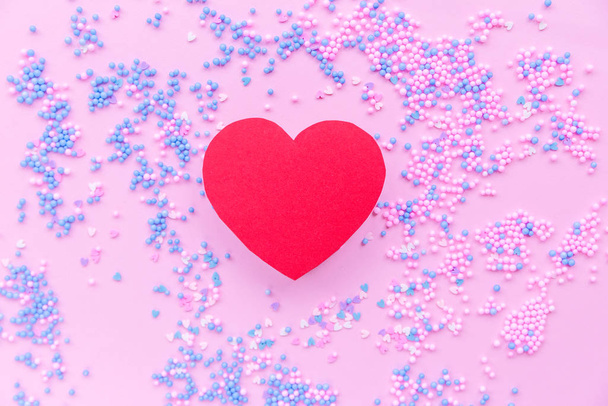 Паперове червоне серце на фоні декоративних кульок в синьо-рожевому
 - Фото, зображення
