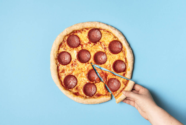 Pizza pepperoni e uma fatia de pizza. Comer salame de pizza
 - Foto, Imagem
