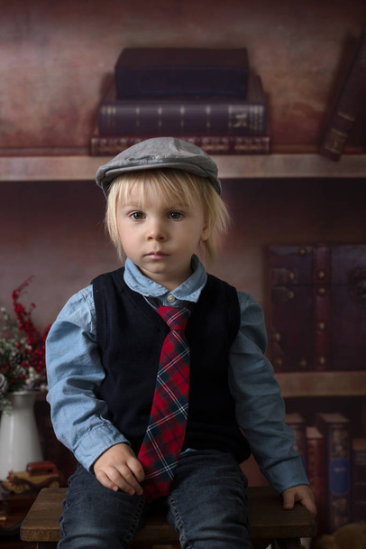 Sweet toddler boy, dressed smart casual, sitting on a wooden cha - Φωτογραφία, εικόνα