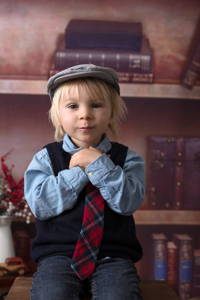Sweet toddler boy, dressed smart casual, sitting on a wooden cha - Zdjęcie, obraz