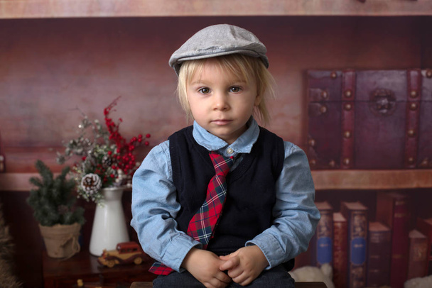 Sweet toddler boy, dressed smart casual, sitting on a wooden cha - Zdjęcie, obraz