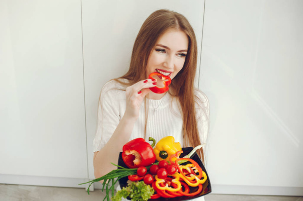 Beautiful woman prepare food in a kitchen - Fotoğraf, Görsel