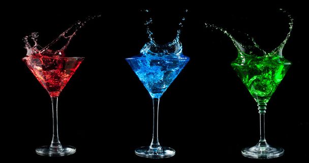 Red cocktail splashing into glass on black - Valokuva, kuva