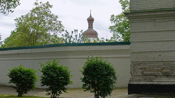 Part of the stone fence in the Kiev Pechersk Lavra and Clock Tower - Photo, Image