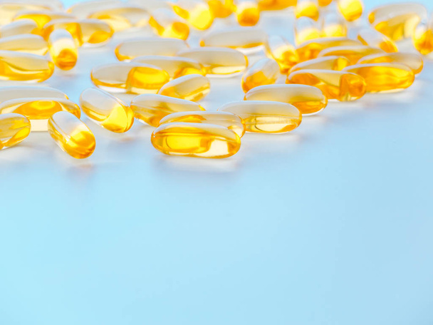 Makro pozadí žluté pilulky s konopným olejem nebo kapsle s omega tři. - Fotografie, Obrázek