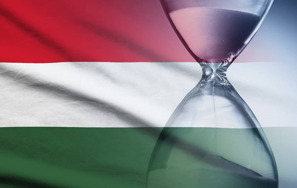 Hourglass over the flag of the Hungary - 写真・画像