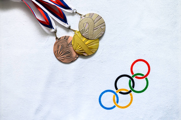 TOKYO, JAPAN, JANUARY. 20. 2020: Gold silver and bronze medal on white background, olympic circles - Foto, imagen