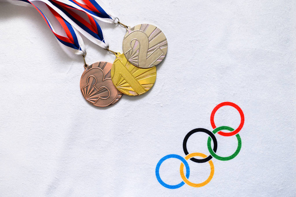 TOKYO, JAPAN, JANUARY. 20. 2020: Gold silver and brone medal, olympic circles, summer olympic game, victory ceremony concept photo, white edit space - Foto, afbeelding