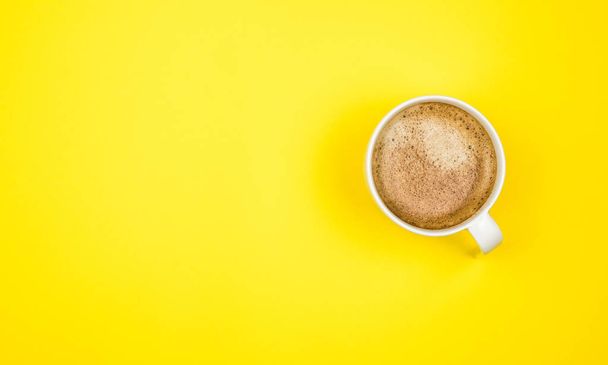 A cup of black coffee on yellow background. View from above. copy space - Fotografie, Obrázek