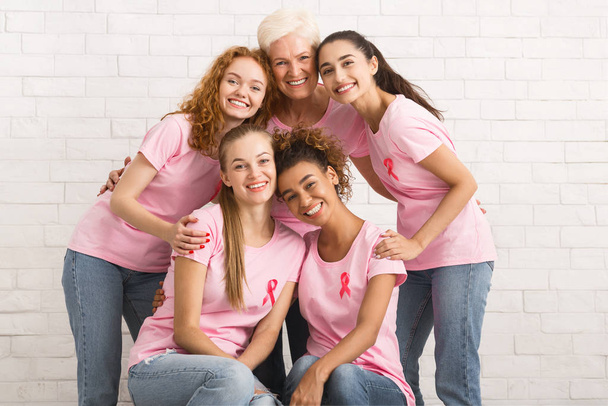 Mulheres multirraciais em camisetas com fitas posando sobre a parede branca
 - Foto, Imagem