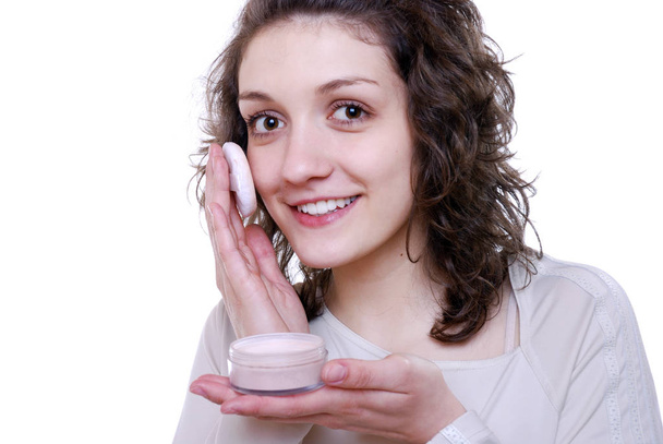 young woman applying moisturizer cream on her face - Fotó, kép