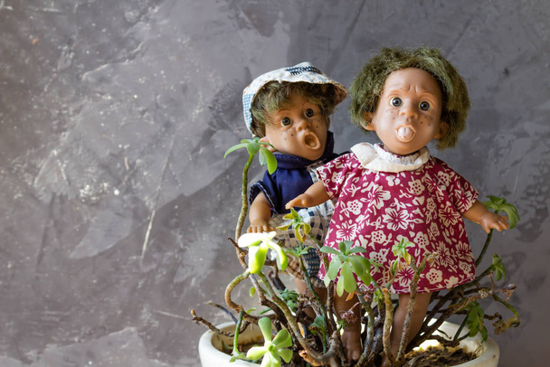 Antiche, spaventose, brutte bambole davanti al muro di cemento. - Foto, immagini