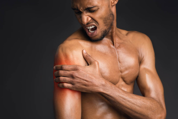 Hombre negro guapo sin camisa que sufre de dolor en el brazo
 - Foto, Imagen