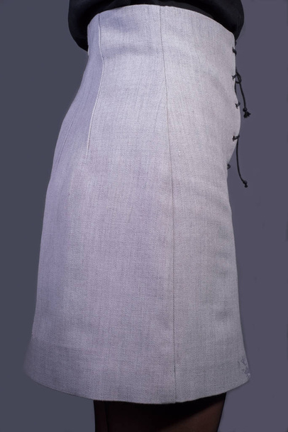reclame foto van een vrouwelijke grijze rok, design rok gemaakt van hoge kwaliteit gebreide stof, op een grijze achtergrond - Foto, afbeelding