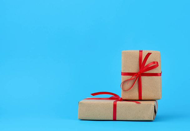 stack of boxes wrapped in brown paper and tied with a red bow, g - Photo, Image