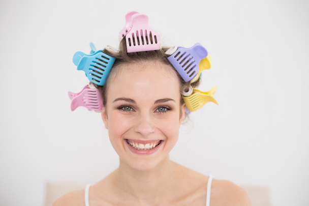 Smiling woman in hair curlers looking at camera - Fotó, kép