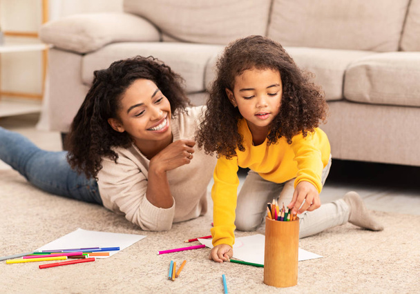 Afro mère et fille dessinant passer du temps ensemble à la maison
 - Photo, image