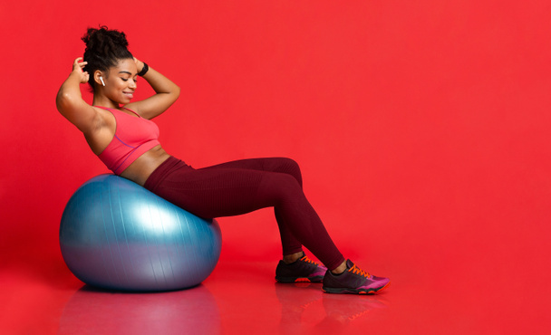Mujer atlética joven haciendo ejercicio con la pelota de fitness
 - Foto, imagen