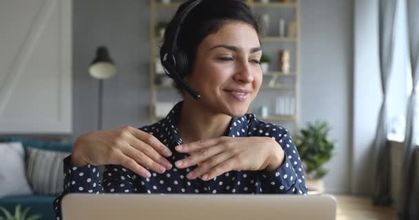 Happy indian young woman wear headset communicating by conference call - Filmmaterial, Video