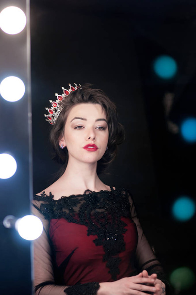 Gorgeous proud queen in red dress watch in mirror. Symbol of power - Foto, Imagem