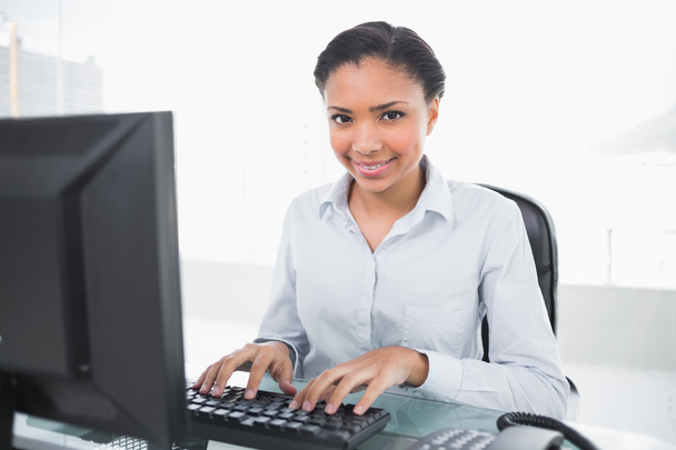 Content young businesswoman typing on her computer - Foto, imagen